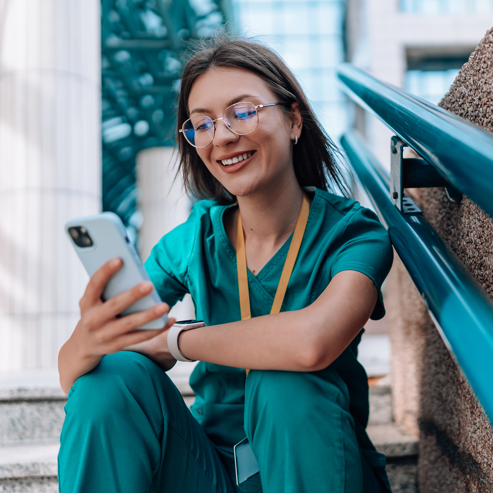 renewal-ndbon A nurse sitting on steps while reading on her phone